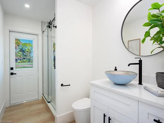 Bathroom with vanity, a shower stall, light wood-plank tile finished floors, and recessed lighting