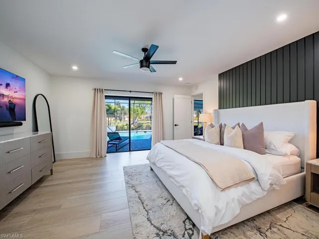 Bedroom with access to pool/lanai, ceiling fan, light wood-plank tile floors, an accent wall, and recessed lighting