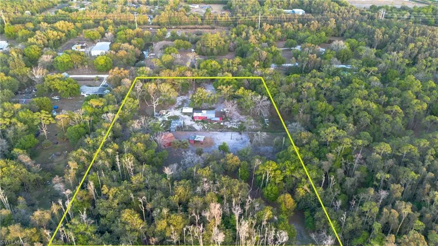 Aerial overview of property's location with property boundaries highlighted and a heavily wooded area