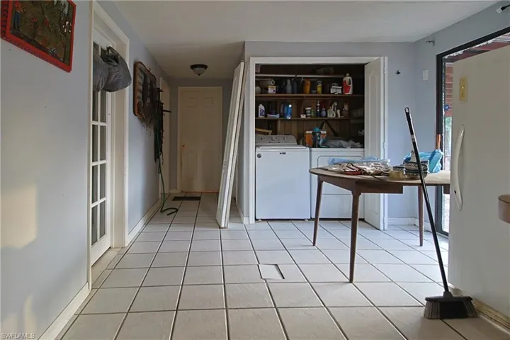 Hall with light tile patterned floors and separate washer and dryer