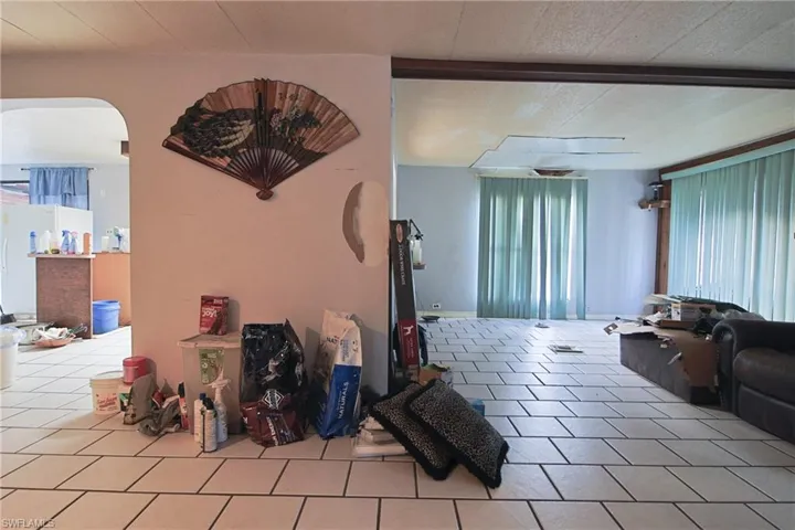 Tiled living area featuring arched walkways and wooden ceiling
