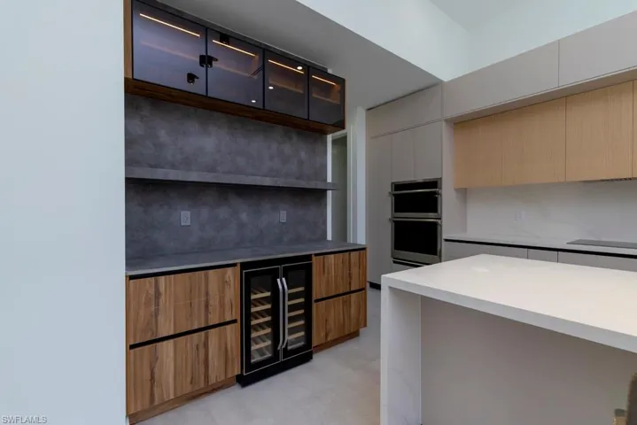 Unfurnished living room with a raised ceiling, recessed lighting, a high ceiling, concrete flooring, and a ceiling fan