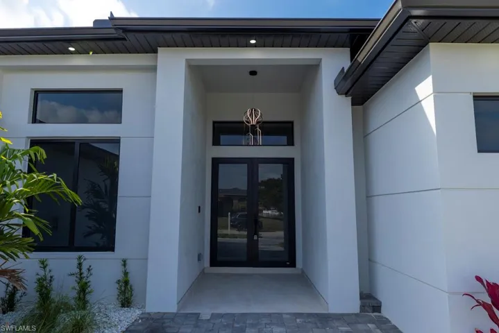 Entrance to property featuring stucco siding and french doors