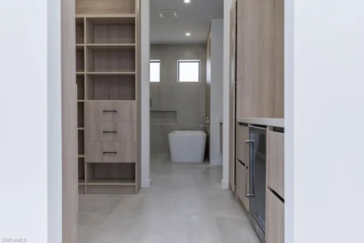 Kitchen featuring modern cabinets, wine cooler, glass insert cabinets, and double oven