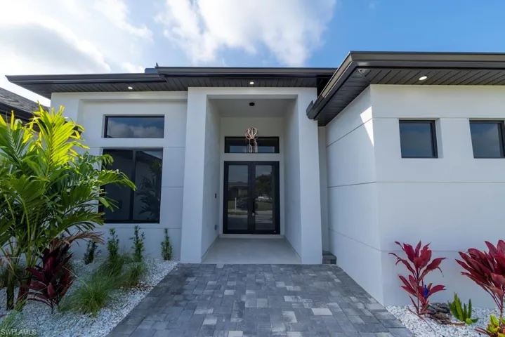 View of front facade featuring a garage, decorative driveway, and a front lawn