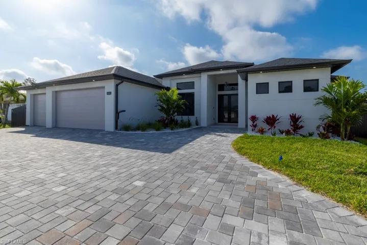View of front of house featuring a front lawn, a garage, decorative driveway, and a residential view