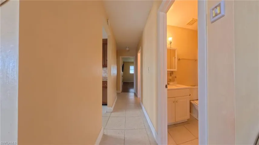 Hall with light tile patterned floors and baseboards
