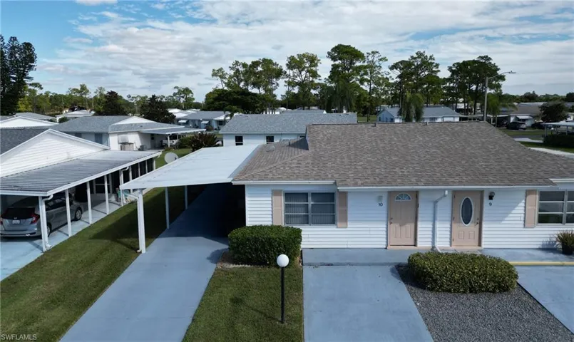 View of front of home featuring roof with shingles, a residential view, and concrete driveway