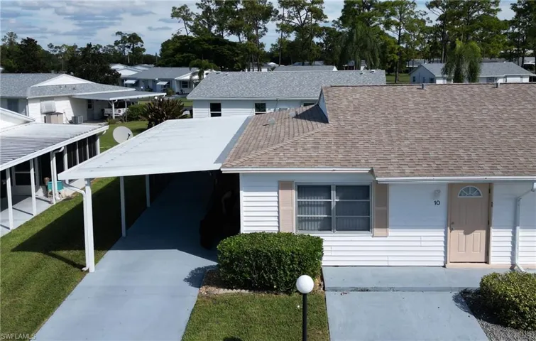 View of front of property featuring roof with shingles, concrete driveway, a residential view, and a front lawn
