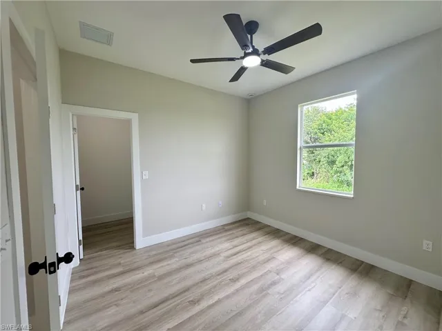 Bathroom with a textured wall, wood finished floors, and a shower