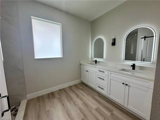 Empty room featuring a raised ceiling, light wood finished floors, recessed lighting, crown molding, and a ceiling fan