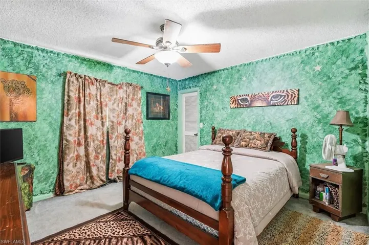 VIRTUALLY STAGED Bedroom featuring green textured walls and light-colored carpeting