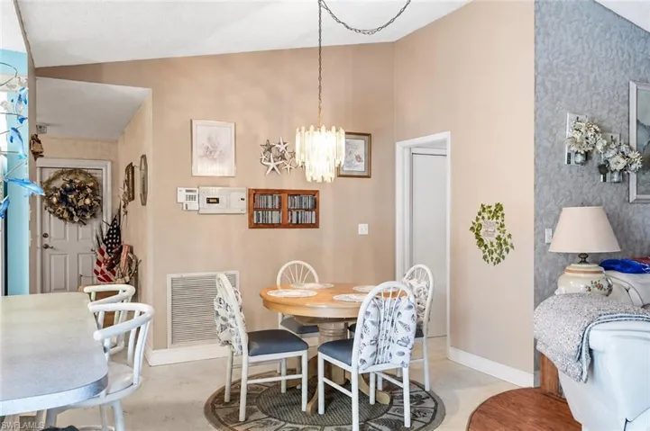 VIRTUALLY STAGED Vaulted ceilings define the dining area, featuring a decorative chandelier and a round table