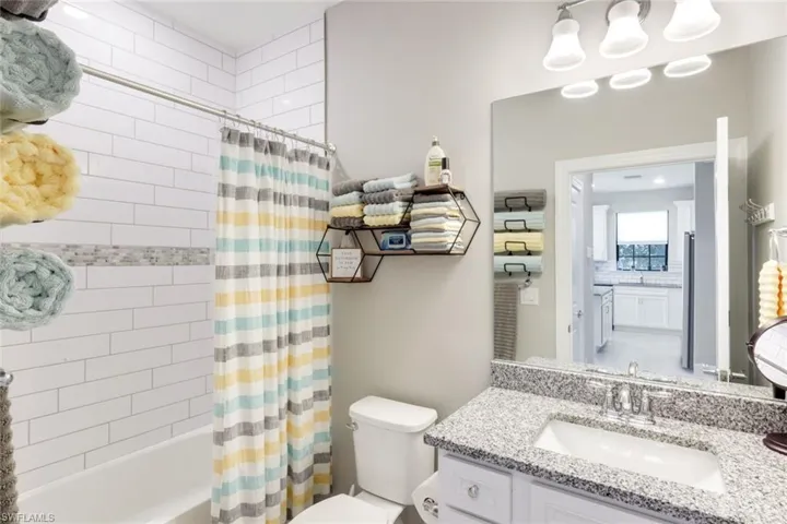 Full bathroom with vanity and shower / bathtub combination with curtain