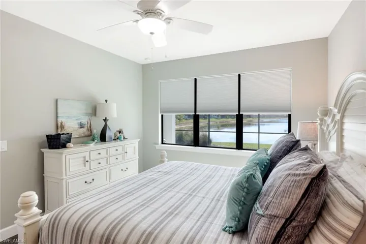 Bedroom featuring a ceiling fan and a water view