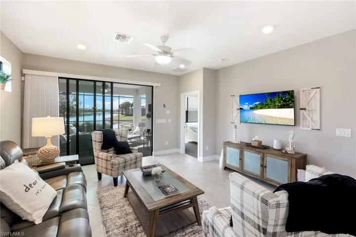 Living area featuring a ceiling fan, recessed lighting, and light tile patterned flooring