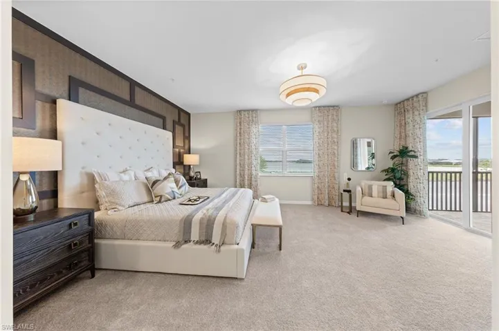 Bedroom featuring access to outside, an accent wall, and light colored carpet