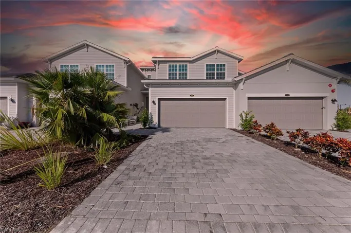 Traditional home featuring decorative driveway and a garage