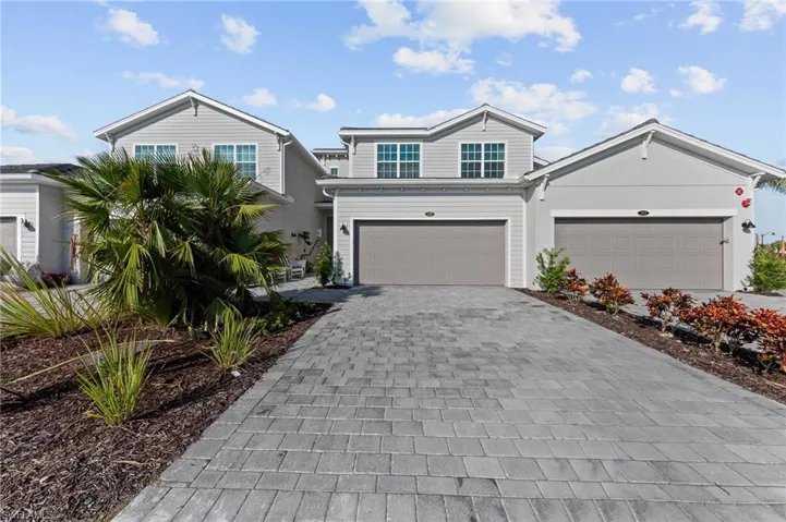 Traditional home featuring decorative driveway and a garage