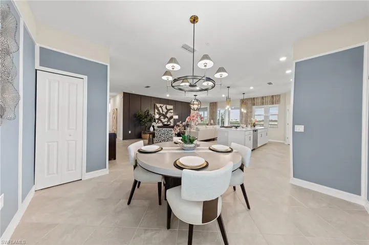 Dining area with a chandelier, light tile patterned floors, and recessed lighting
