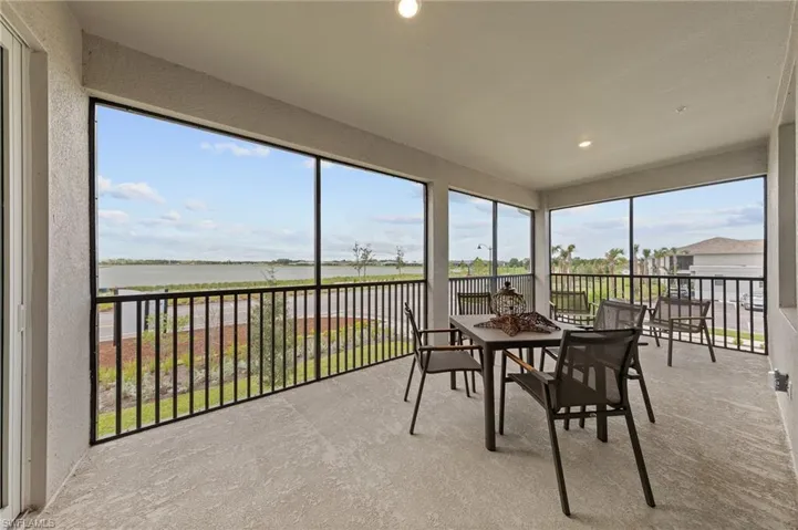 Sunroom with a textured wall, carpet floors, and a water view
