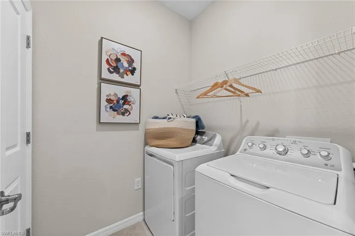 Washroom featuring independent washer and dryer and a textured wall