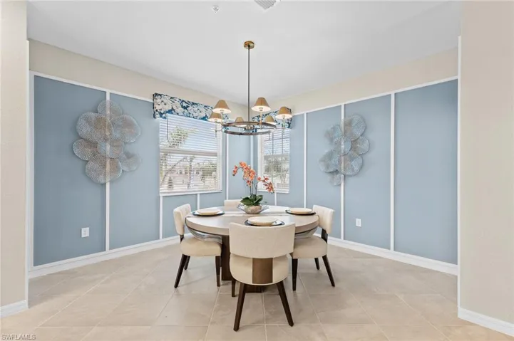 Dining room with a chandelier and light tile patterned flooring