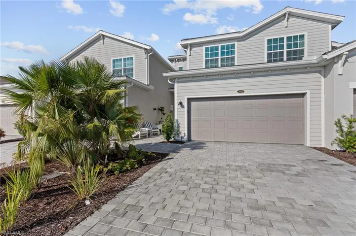 View of front of home with decorative driveway and an attached garage