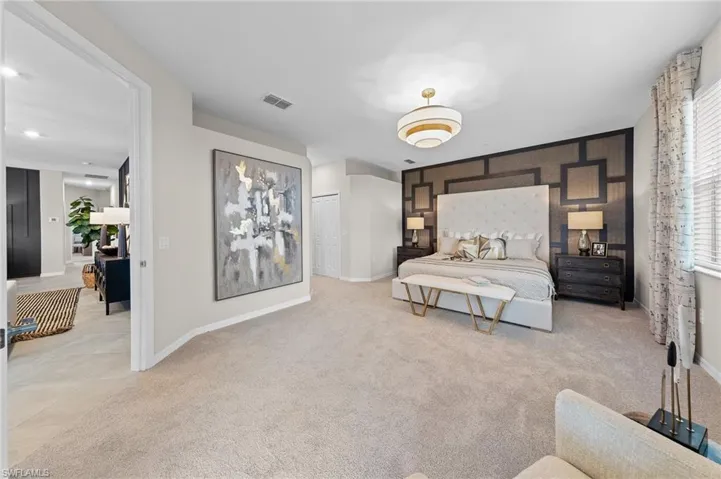 Bedroom featuring an accent wall and light colored carpet