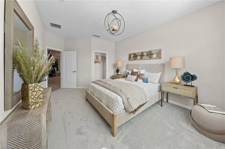 Carpeted bedroom with a closet and a chandelier
