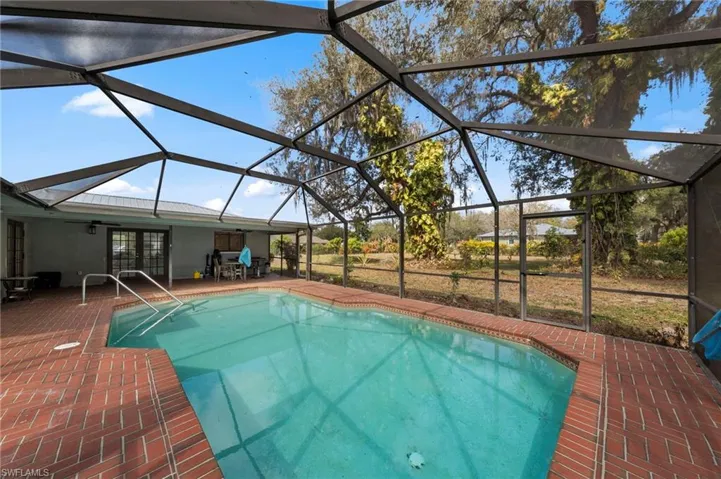 Outdoor pool with french doors, a sunroom, glass enclosure, and a patio