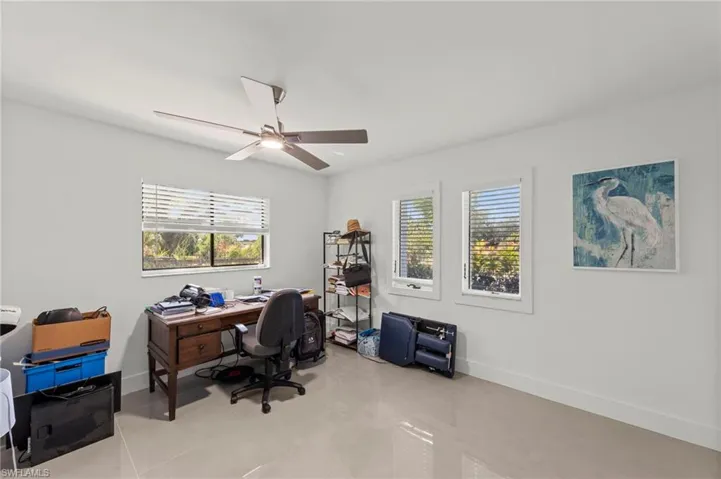 Office area featuring light tile patterned flooring and ceiling fan