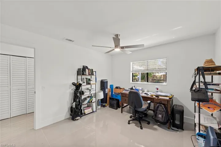 Office area featuring light tile patterned floors and ceiling fan