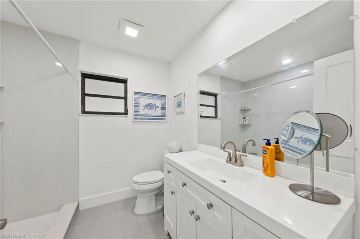 Full bathroom with vanity, a shower, and light tile patterned flooring