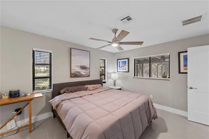 Bedroom featuring multiple windows, a ceiling fan, and light tile patterned floors