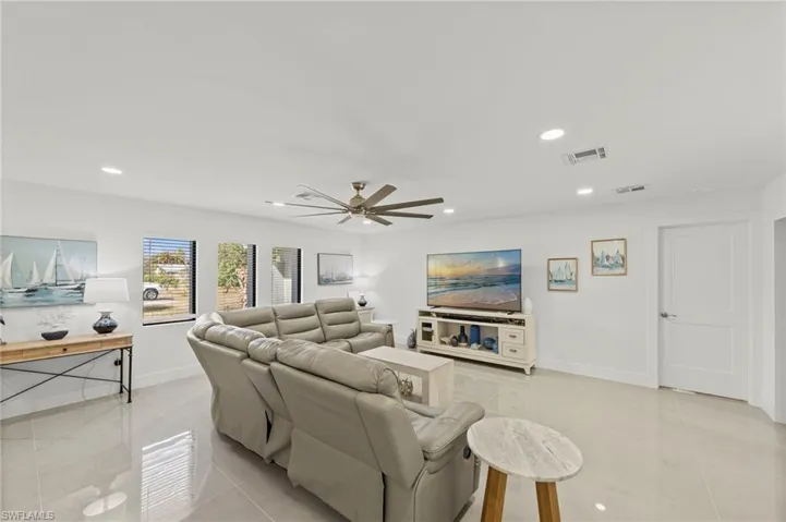 Living area featuring light tile patterned floors, a ceiling fan, and recessed lighting