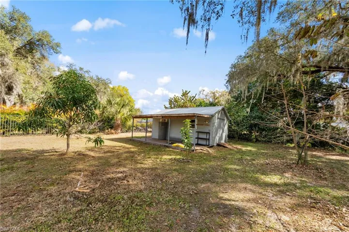 View of green lawn featuring an outbuilding