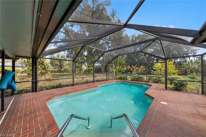 Outdoor pool with a lanai, a sunroom, and a patio area