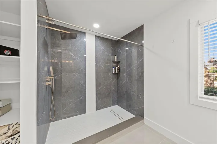 Full bathroom featuring a marble finish shower and recessed lighting