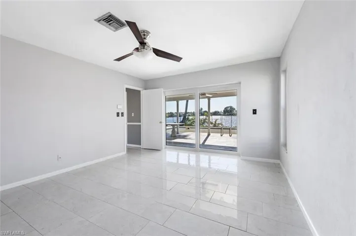 Primary bedroom with ceiling fan and slider to the lanai
