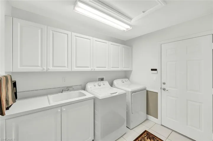 Laundry with large storage closet, mud sink & plenty of storage space.