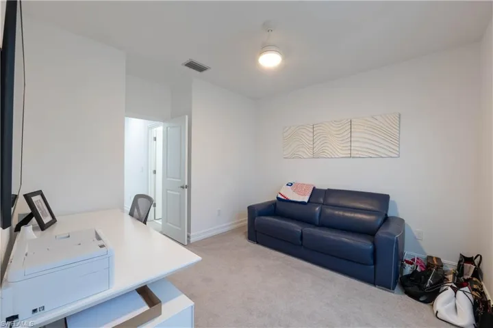 Home office with light carpet and baseboards