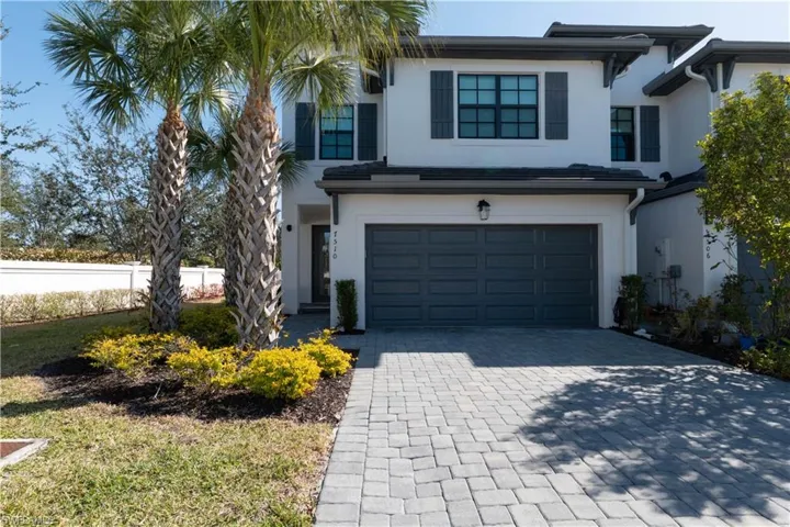View of front of house with stucco siding, an attached garage, and decorative driveway