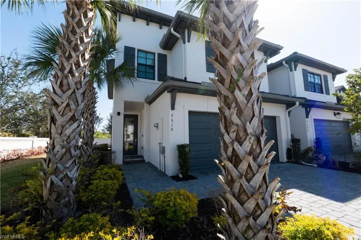 View of front of home featuring stucco siding, a garage, and decorative driveway