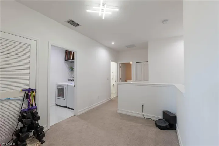 Spare room with light carpet, washing machine and clothes dryer, and recessed lighting