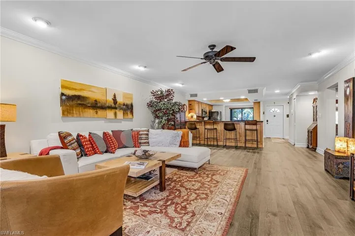 Living area featuring recessed lighting, visible vents, light wood-style floors, crown molding, and ceiling fan