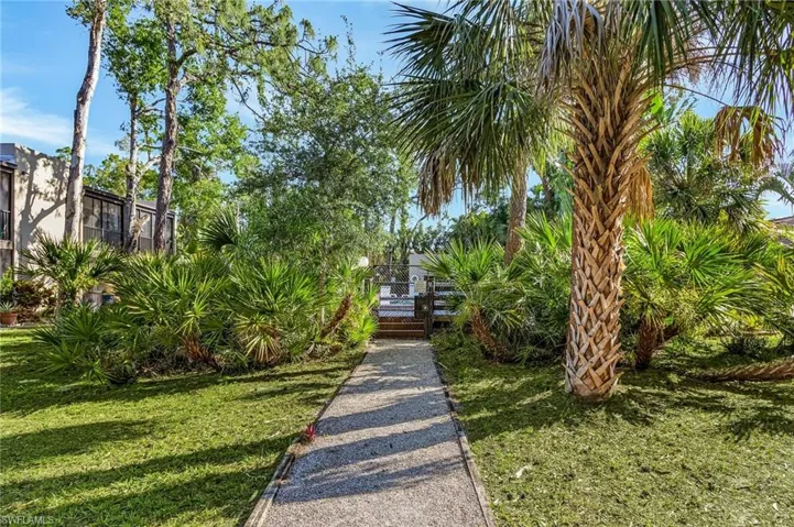 View of community featuring a gate and a yard