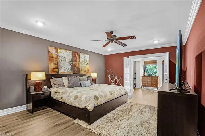 Bedroom featuring a ceiling fan, crown molding, light wood-type flooring, french doors, and baseboards