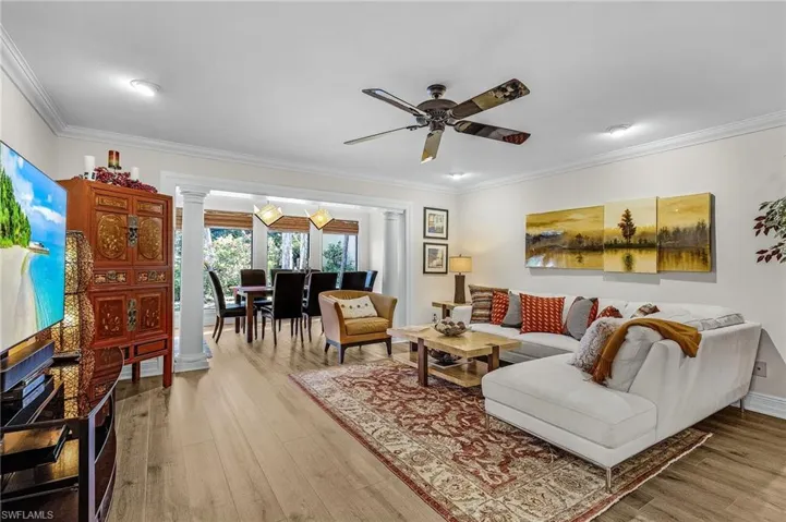 Living area with light wood-type flooring, crown molding, and ceiling fan