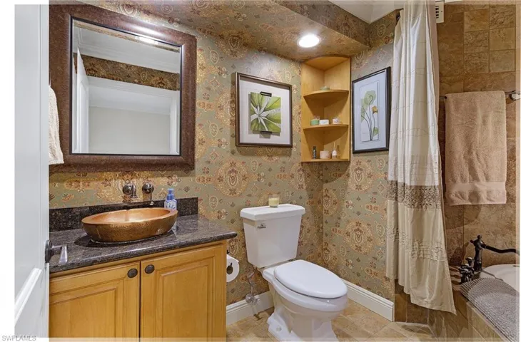 Full bath with wallpapered walls, vanity, baseboards, toilet, and tile patterned flooring
